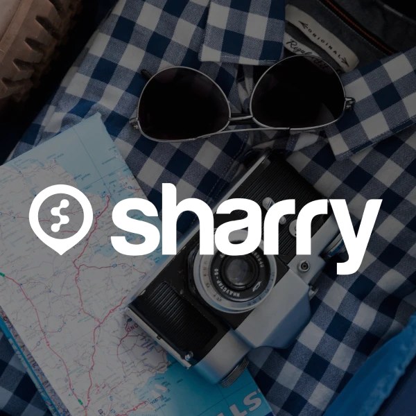 логотип і назва компанії Sharry на фоні фотоапарата та окулярів